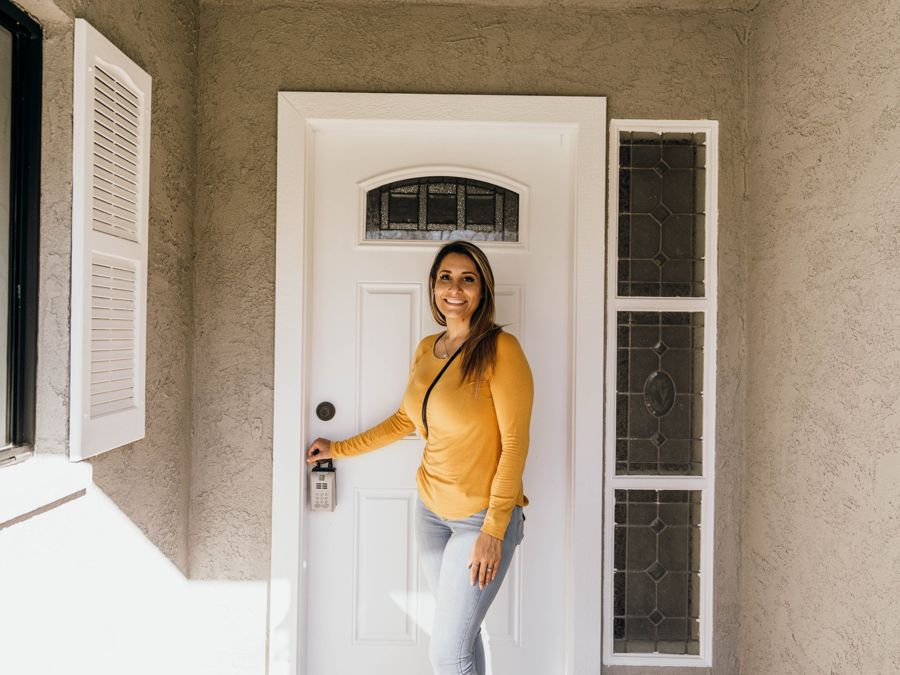 Christina at a client's front door with a lockbox